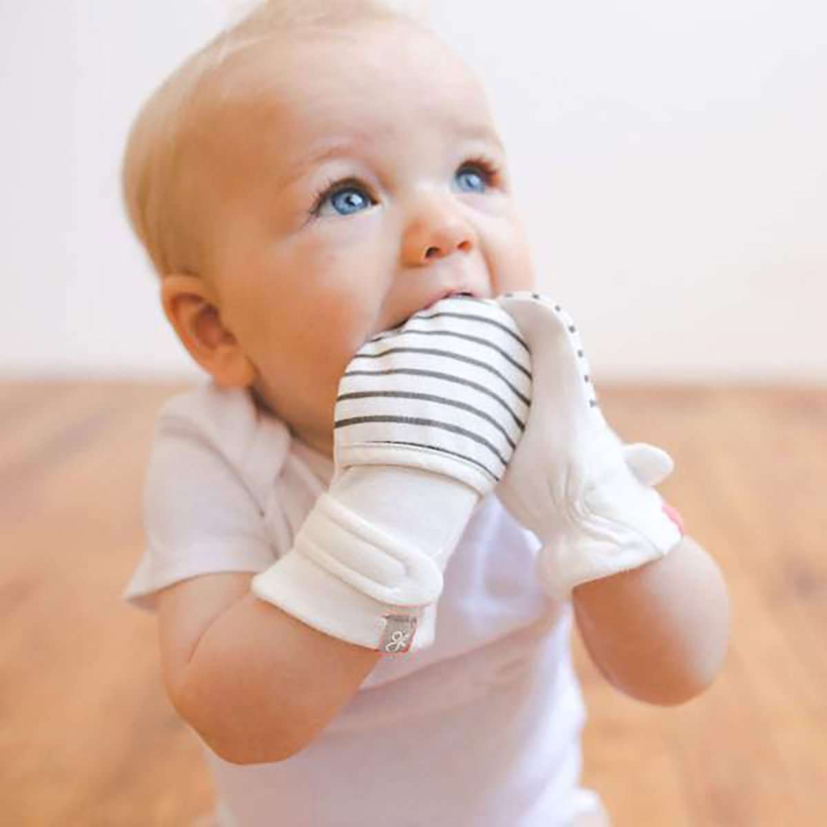 2-PACK MITTS in soft white with gray horizontal stripes, worn by a baby with adjustable wrist closures