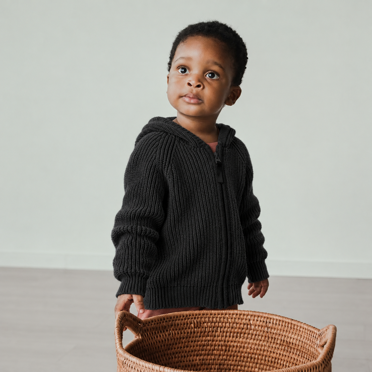 KNIT HOODIE in shadow gray chunky knit with an oversized hood, worn by a toddler outdoors