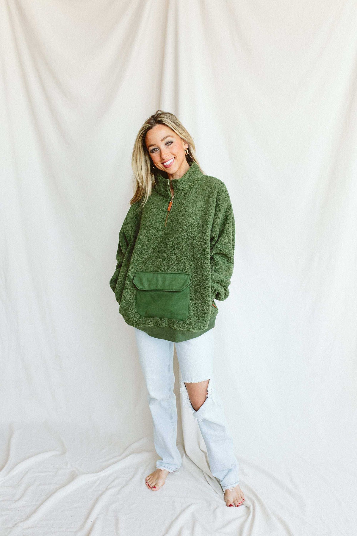 Adult Sherpa Zip Pullover in spruce green with plush fleece texture, orange half-zip, and a large front pocket