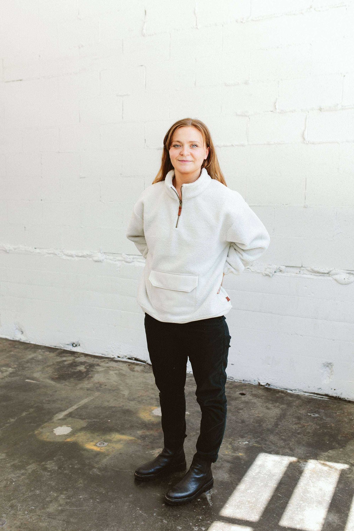 ADULT SWEATSUIT PANT in black with a relaxed fit and tapered legs, worn with a white quarter-zip pullover