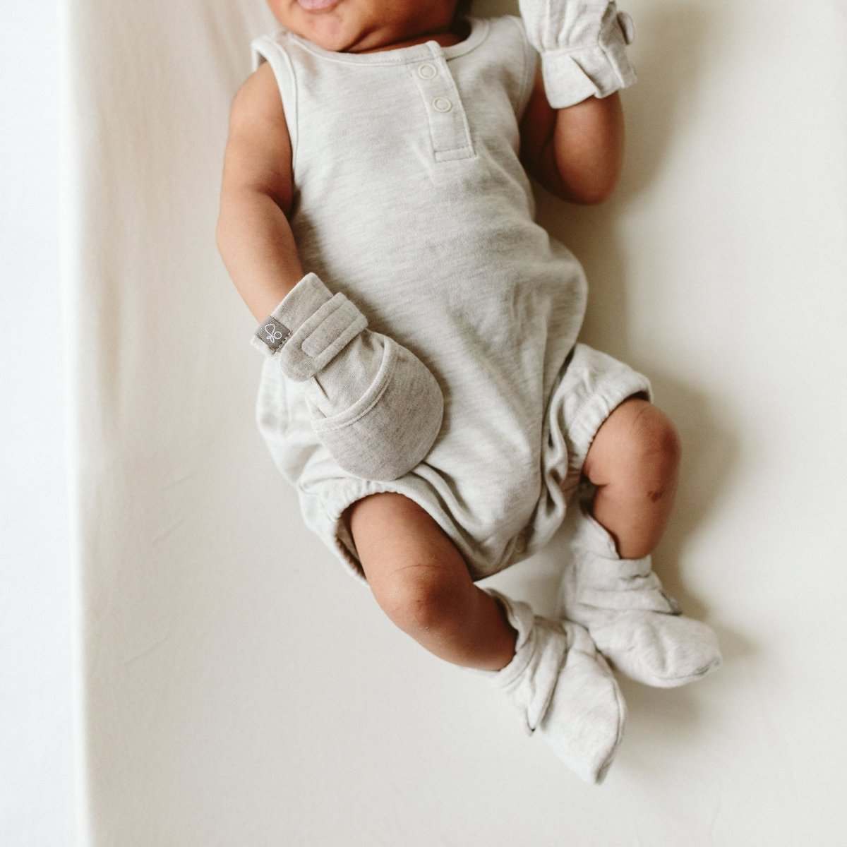 PREEMIE STAY ON MITTS in storm gray, soft fabric with adjustable folded cuffs worn by a baby