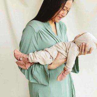 STAY ON 2-PACK BOOTS in soft pink, worn by a baby held in a cream outfit with matching wraparound closures