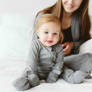 STAY ON 2-PACK MITTS, soft gray baby mitts with adjustable closures worn on a baby's hands