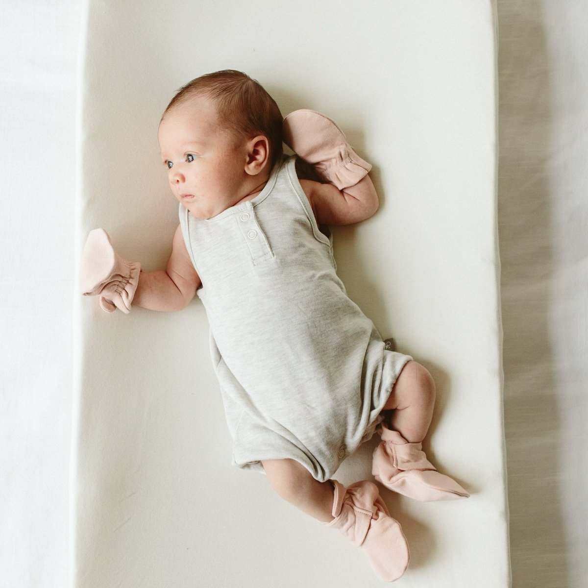 stay on 2-pack mitts in pale pink fabric, worn by a baby with a soft gathered cuff design