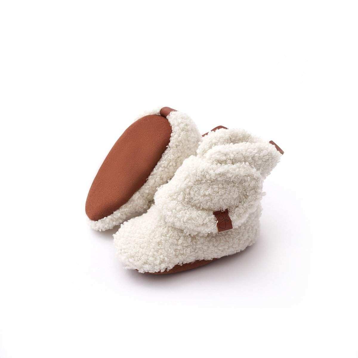 Stay on Sherpa Boots in cream sherpa fleece with brown leather accents and an adjustable wraparound closure