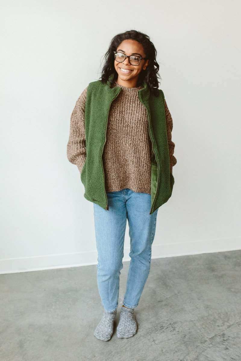 WOMENS CHUNKY KNIT SWEATER in brown chunky knit, with a relaxed fit and ribbed neckline, worn under a green vest