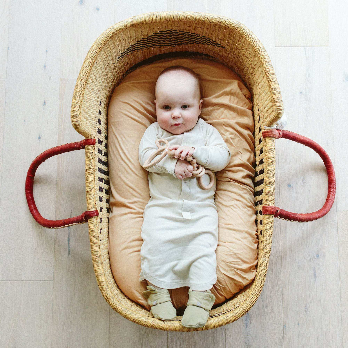 24 HOUR CONVERTIBLE GOWN in soft ivory fabric, worn by a baby with integrated mitts and a long gown shape