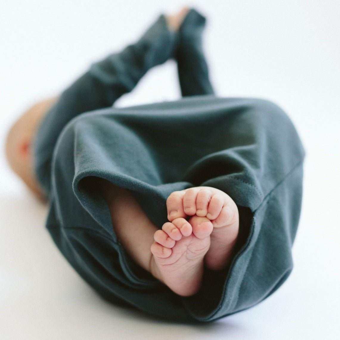 24 HOUR CONVERTIBLE GOWN in midnight blue, soft bamboo-cotton fabric with a gathered opening showing baby's feet