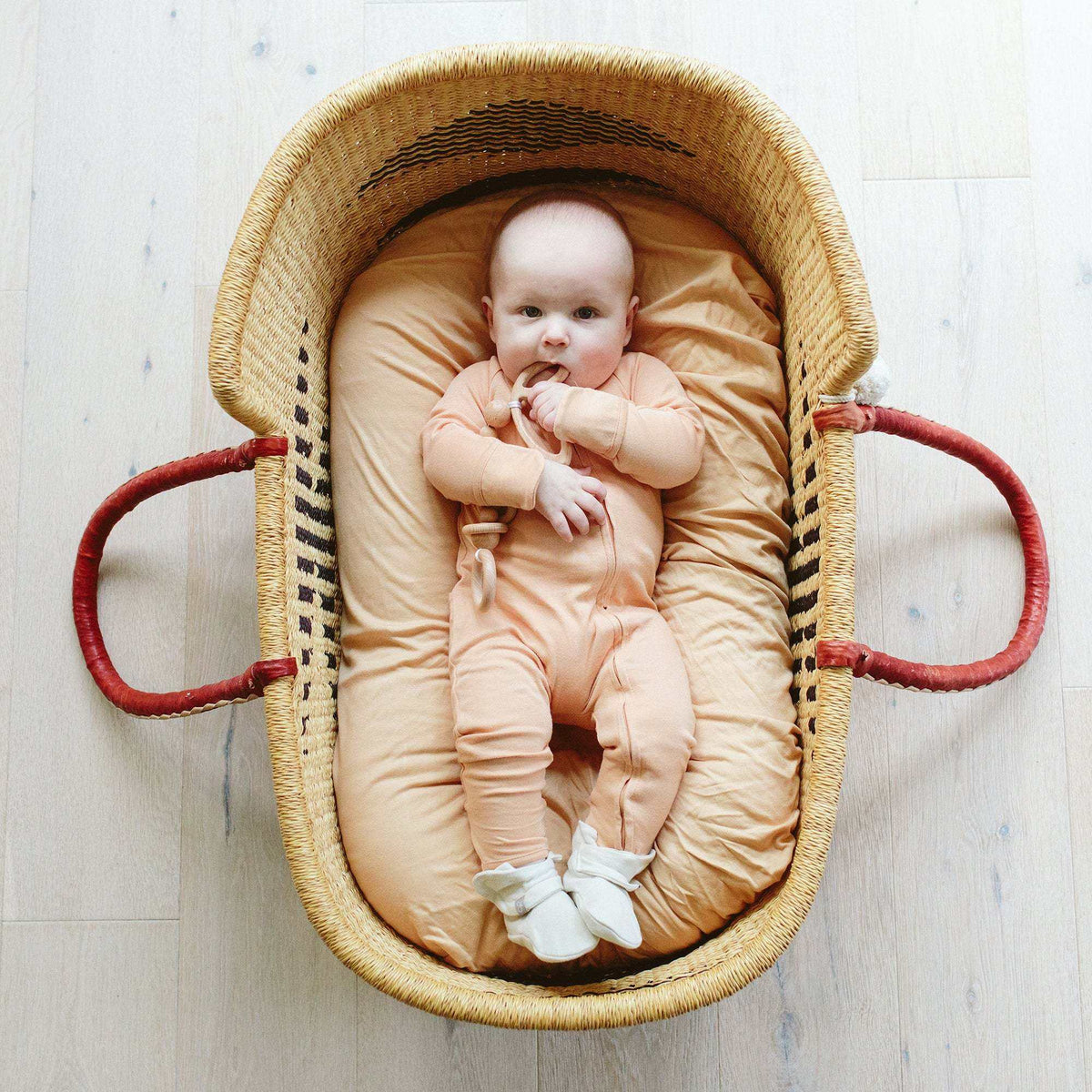 GROW WITH YOU FOOTIE in peach, a soft solid-colour baby one-piece with long sleeves, covered feet and front zip
