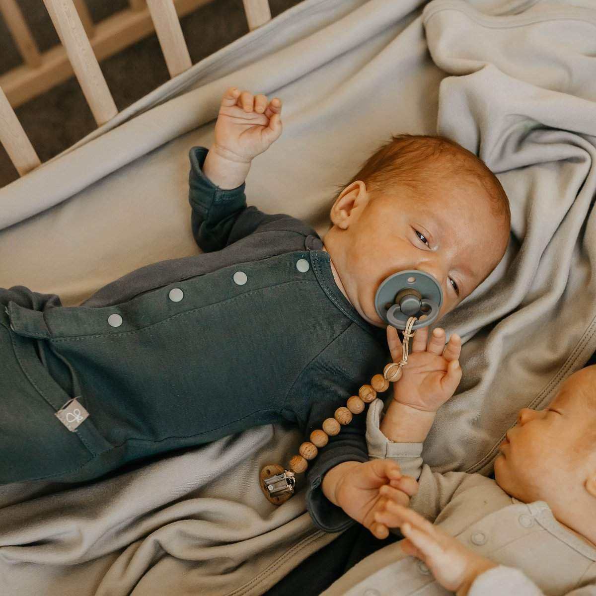 Preemie Sleep Set with a dark sage green long-sleeve gown featuring snap closures, worn by a baby with covered hands