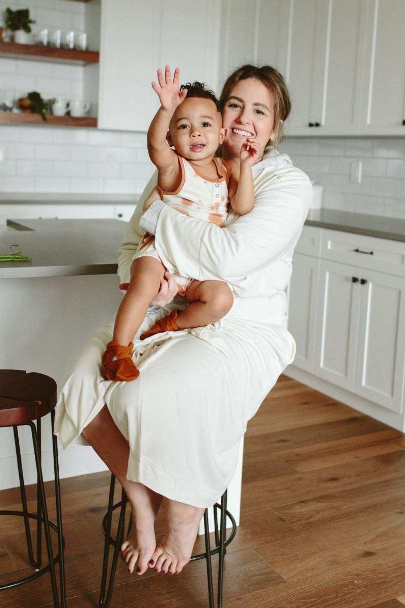 SECOND CHANCE WOMENS ROBE in white cloud terry, a soft wrap-style robe worn by a mother holding her child