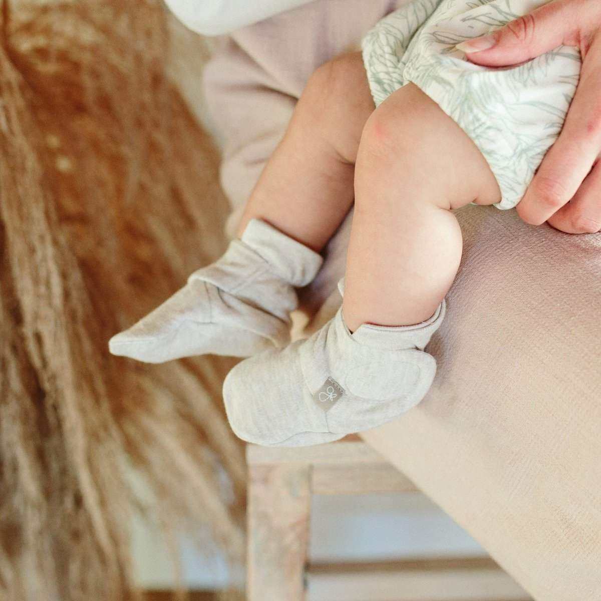 STAY ON 2-PACK BOOTS in soft pale gray fabric, worn by a baby with adjustable folded cuffs and a small emblem