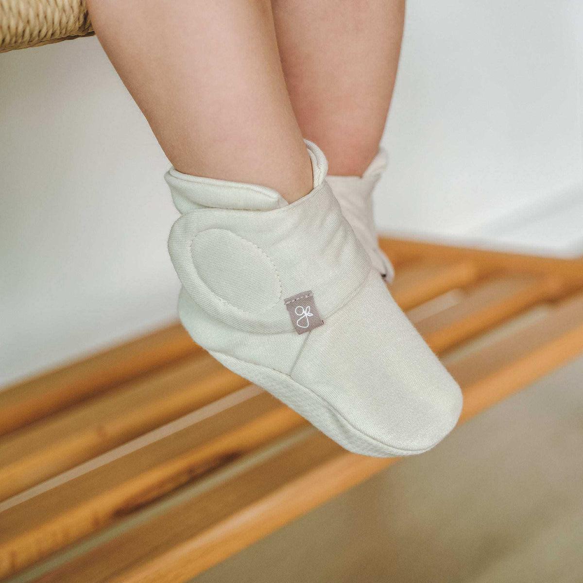 STAY ON BOOTS in soft ivory fabric with a padded adjustable wrap closure and small logo tab
