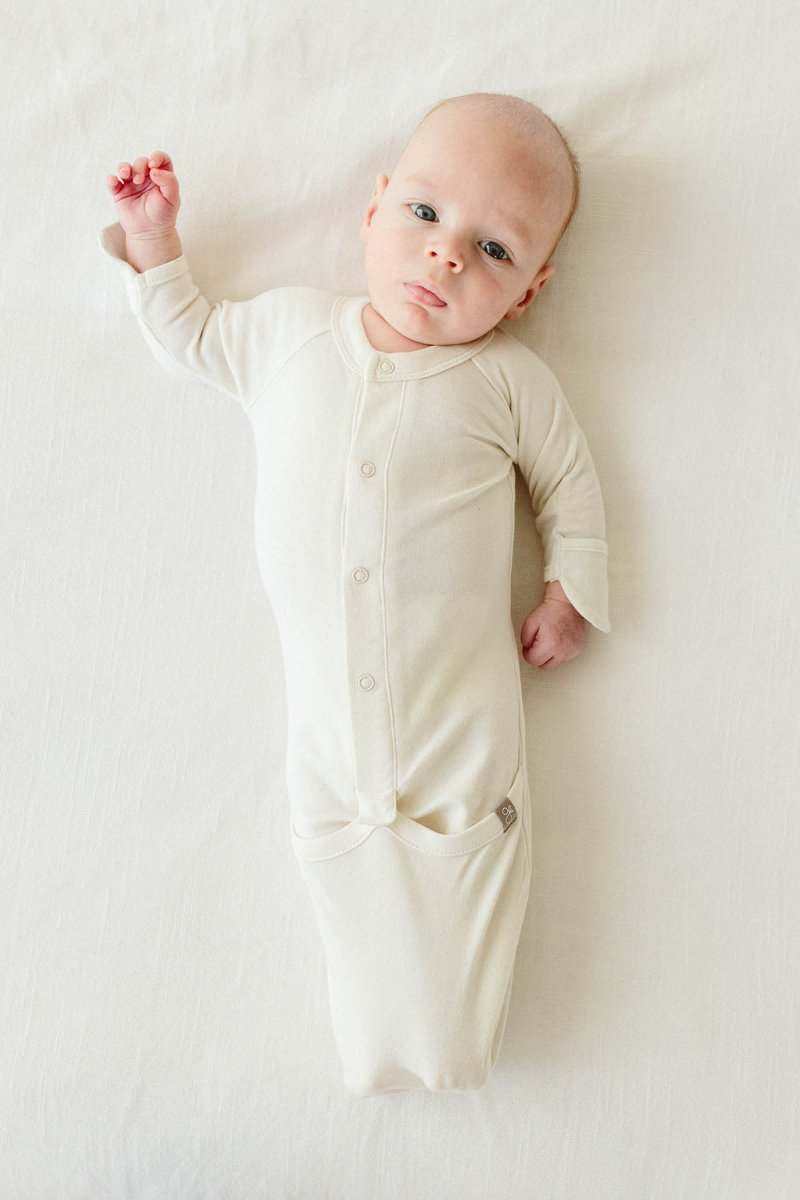 Welcome Home Set baby gown in soft ivory fabric, featuring long sleeves, front snaps and a gathered convertible bottom